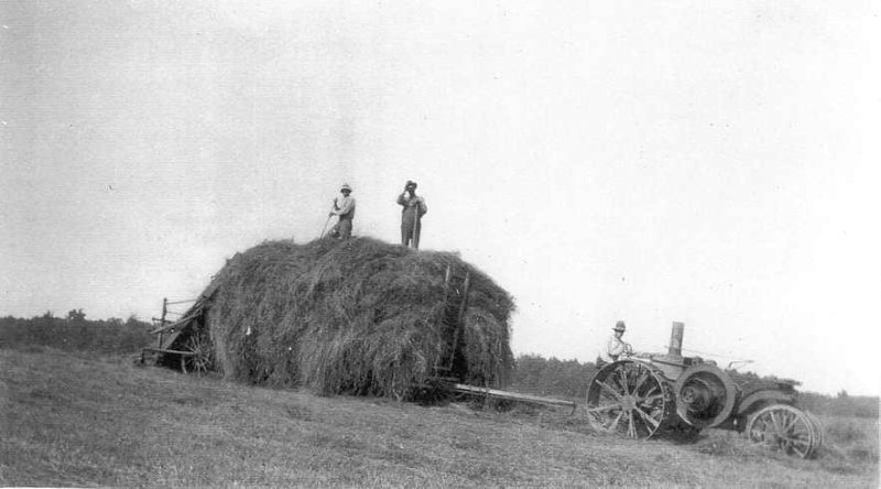 Haying, ca. 1915 John Trant and Lewis William Walker on hay wagon Jacob Walker driving tractor